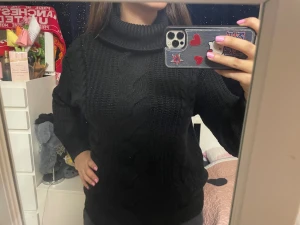 H&M’s svart polotröja med flätstickning - Mysig svart polotröja med grov flätstickning och ribbade muddar. Tröjan har lång ärm och hög krage som ger extra värme. Perfekt för dig som gillar en chill och stilren look under kalla vinter dagar :)