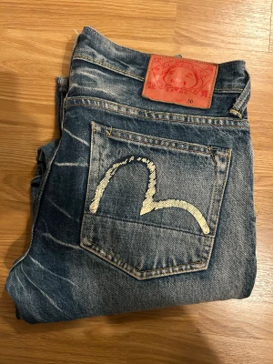 Evisu Genes Jeans - Riktigt snygga straight fit Evisu jeans med snygg tvätt. Använda rätt sparsamt då de är lite små i midjan för mig men annars ett riktigt snyggt par jeans som jag önskade passar mig. Midjan är strlk 30 men längden är ungefär 32. 