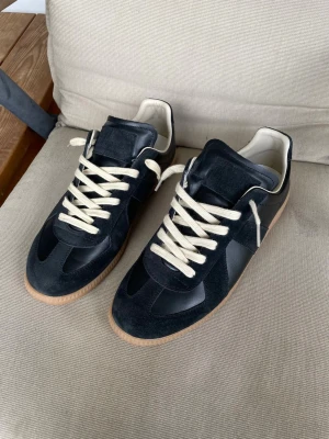 Maison Margiela Gats - Hej! Säljer ett par sjukt snygga Maison Margiela Gats. De är i storlek 43. Passar tts. Äkta. Har kvitto osv. Den vanliga svarta färgen. Skriv om ni har några frågor. Vill ha runt 2900 för dem i princip fast pris. Sjuk deal. Har ni lite tålamod kan ni till och med sälja för mer tror jag. Ska snart på utbyte till Spanien i ett halvår så säljer de gärna snabbt för ett bra pris. Väldigt bra skick. 