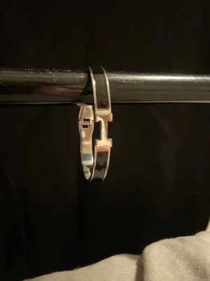 Silverfärgat H-armband - Snyggt och stilrent armband i silverfärgad metall med svart emalj. Armbandet har den klassiska H-detaljen framtill och ett smidigt lås. Perfekt för dig som gillar exklusiva accessoarer med minimalistisk vibe.