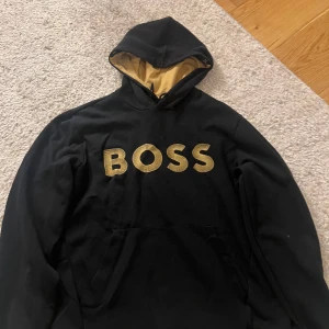 Hugo boss Hoodie - Svart hoodie från BOSS med stor gul BOSS logga på bröstet och gul insida i huvan. Pris kan sänkas vid snabb affär. Hör av er vid intresse eller liknande😁