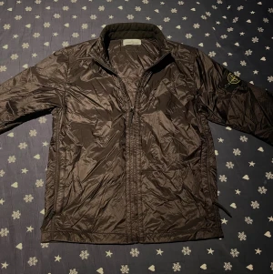Svart vindjacka från Stone Island - Stilren svart vindjacka från stone island. Perfekt för lite varmare höst/vår dagar. Jackan är i väldigt bra skick och i skönt material. Hör jättegärna av dig vid minsta lilla fundering om jackan eller pris!💯🔥👍🏼