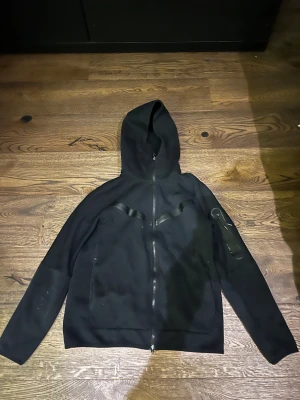 Svart Nike tech fleece  - Svart Nike tech fleece, har några få vita färgfläckar på armen. Storlek S men passar även XS. Går att diskutera om priset.