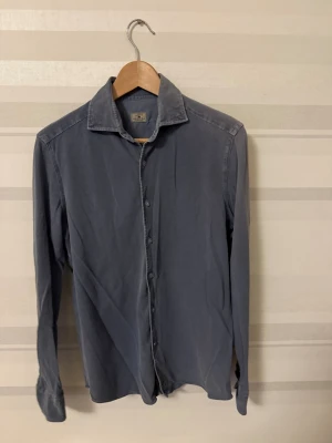 Blå långärmad skjorta från sonrisa - Snygg blå skjorta från Sonrisa i mjuk bomull. Klassisk krage, knappar hela vägen och långa ärmar med manschett. Passar dig som vill ha en normal passform och diskret look. Om ni funderar på något så fråga gärna. Priset kan diskuteras. 