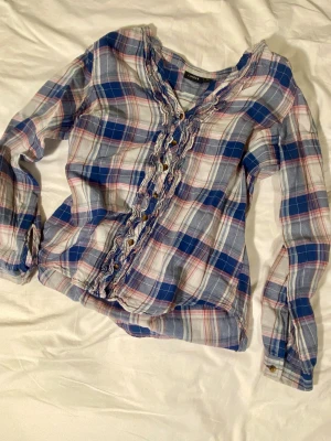 Lindex 2000s rutig skjorta - Den här skjortans modell är så gullig och jag älskar verkligen mönstret. Volangerna är så fina och den sitter verkligen jättefint. Passar fint på mig och jag är XS/S. #2000s #skjorta #rutig #flannel #bomull