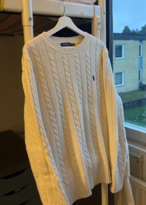 Vit Polo Ralph Lauren kable stickat - Säljer en vit Ralph lauren tröja. Storleken är XL fast om man har L så känns det perfekt vid armarna för att få dig se större ut💪.Har haft på mig den ett par gånger och gillar inte ljusa kläder. Inte min stil och färg därför säljer jag den.                    Priset kan diskuteras vid snabbaffär