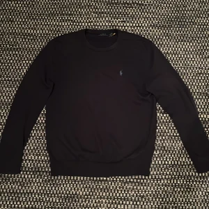 Marinblå tröja från Polo Ralph Lauren M - Marinblå långärmad tröja från Polo Ralph Lauren med klassisk rund hals och broderad logga på bröstet. Tröjan är tillverkad i mjuk bomull och har en stilren, normal passform som funkar till många olika looks.