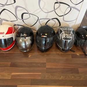 Mopedhjälmar - Fyra coola hjälmar i olika stilar och färger. En svart Nolan, en svart Bullfighter, en svart och silvermönstrad X-lite samt en svart hjälm. Alla har visir och aerodynamisk form, perfekta för MC-åkning. Skriv för fler bilder på specifika hjälmar och storlekar! Hjälmarna är i olika skick så fråga bara på! Pris kan diskutera och varierar från hjälm till hjälm. 100-300kr  Nolan (reflekterade hjälm) XL X-lite (grå) XS/S Bull fighter (svart) M 57 Svart höger M58 (RÖD HJÄLM SÅLD)