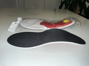 Skoinlägg - Anpassningsbara Svarta ortopediska skoinlägg - Säljer ett par ortopediska skoinlägg med ergonomisk form för extra stöd och komfort. Ovansidan är svart och tillverkad i syntetmaterial, undersidan har röd och gul detalj för stötdämpning. Perfekt för dig som vill ha bättre komfort i dina sneakers eller kängor.Ett par nya skoinlägg som kan anpassas till önskad storlek. Perfekt för att ge extra stöd och komfort i dina skor. 🎁 
