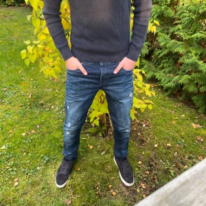 Blå Jack & Jones jeans med slitningar - Säljer ett par blå Jack and Jones jeans med perfekta slitningar och sjukt snygg fade👖| Modellen är ”Tim|Slim fit” och storleken är W31 L32✅| Vid frågor är det bara att skriva!✌🏼