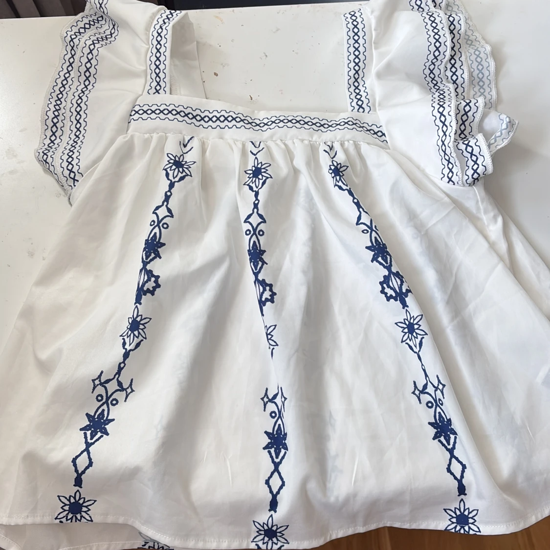 Vit blus med blå broderier