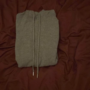 Beige hoodie i kashmirblandning - Mysig beige hoodie med huva och dragsko, tillverkad i mjuk kashmirblandning. Tröjan har långa ärmar, ribbade muddar och en klassisk passform. Perfekt för dig som vill ha en stilren och bekväm look. Fett skön hoodie och knappt använd! Pris går att diskutera.