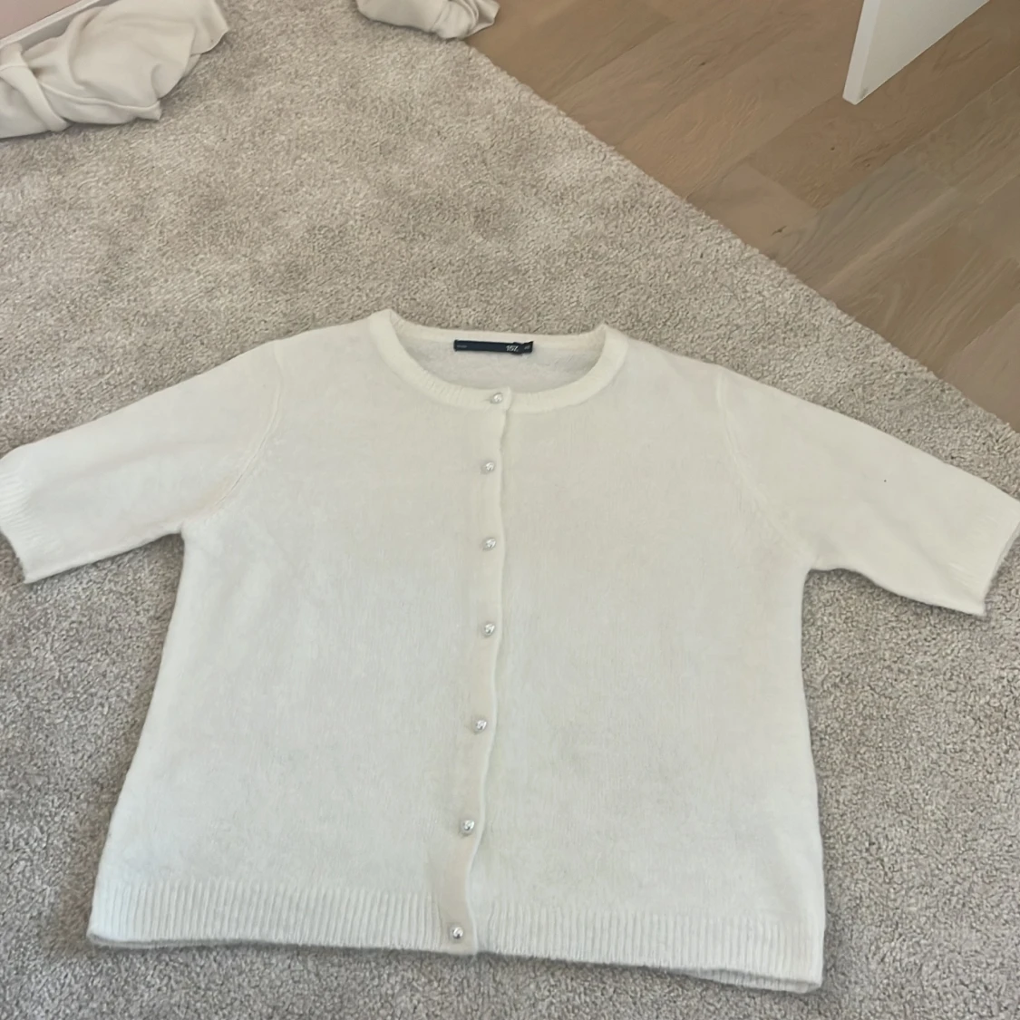 Vit kofta med pärlknappar från 157