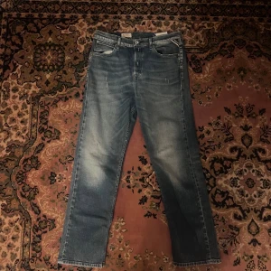 Replay blå slim jeans, stl 28/28 - Säljer ett par blå jeans från Replay i modellen Marillard. Jeansen har raka ben, klassisk femficksdesign och snygga slitningar framtill. De är tillverkade i denim med en tvättad look och har normal passform. Perfekta för dig som gillar en avslappnad stil. Midja 37 längd 95 (39)