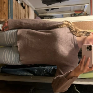 Beige stickad tröja med slits - Mysig beige stickad tröja med rund halsringning och långa ärmar. Tröjan har ribbade muddar och en liten slits på sidorna nedtill, vilket ger en snygg detalj. Perfekt att matcha med jeans för en chill look.