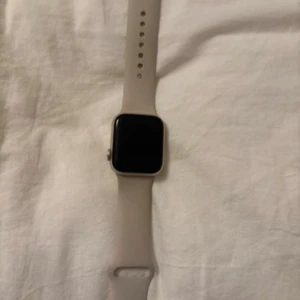 Apple Watch SE (GPS+CELLULAR) Andra Generationen  - Snygg Apple Watch med fyrkantig display. Klockan har en modern look med slät yta och digital krona på sidan. Perfekt för dig som gillar teknik och vill ha koll på allt direkt på handleden.