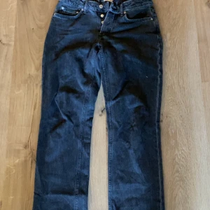 Svart/grå jeansbyxor från 157, S - Snygga svart/grå jeansbyxor från 157 i storlek S. Klassisk femficksmodell med raka ben och knappgylf. Perfekta för dig som gillar en enkel och tidlös stil. Materialet är slitstarkt jeans och färgen är svart/grå. 