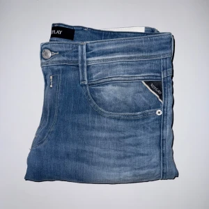 Replay Ljusblå Anbass Jeans - Ljusblå Replay Anbass jeans med klassikt slitna detaljer. Jeansen är använde ett fåtal gånger och har inga skador eller spår av större användning. Storlek W31/L34