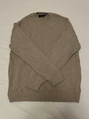 Beige stickad tröja  - Säljer en beige stickad tröja med rund halsringning och ribbade muddar vid ärmslut och nederkant. Tröjan har en enkel, klassisk design och är perfekt för lager på lager under kyligare dagar. Skriv vid minsta intresse, pris kan alltid diskuteras vid smidig affär 😀