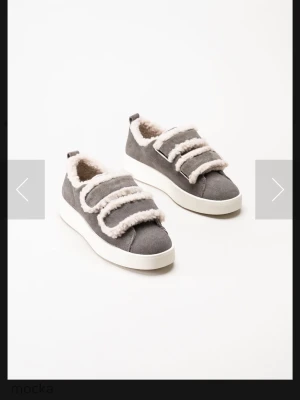 Duffy skor  - Säljer ett par grå sneakers med vit sula och mjuk fuskpäls runt öppningen och på kardborrebanden.  Fick dom i födelsedagspresent för 3 veckor sen men har aldrig andvönt dom endast testat! Storlek 39. Från Duffy nypris 899!