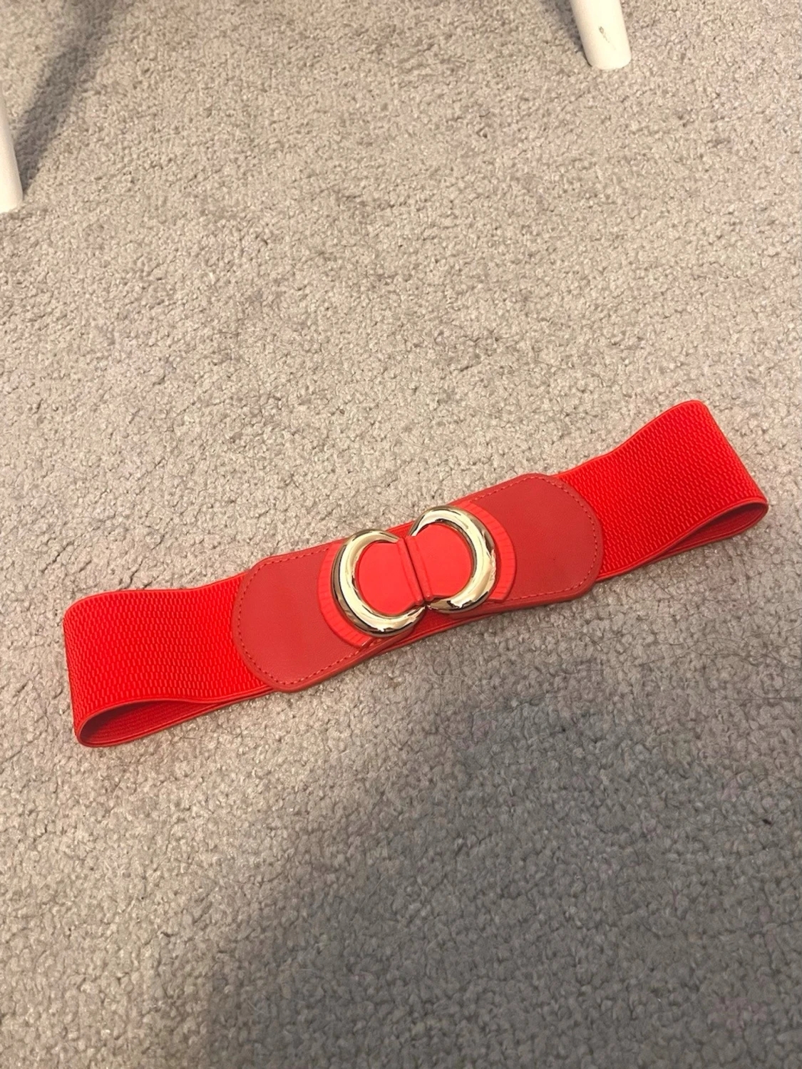 Rött brett bälte med gulddetaljer