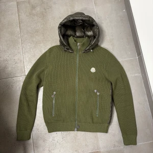 Moncler maglione cardigan - Säljer nu denna riktigt feta oliv gröna Moncler maglione jacka själv klart äkta och verifierings kod ges ut vid intresse. Jackan är i fint skick och passar M/L🤩