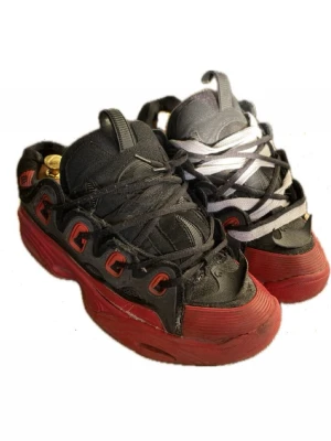 Osiris d3 2001 - Unika sneakers i svart och rött med chunky sula och kontrasterande snörning. Skorna har detaljer i rött längs sulan och öglor, samt en mix av svarta och vita skosnören. Materialet är syntet och textil, och designen är sportig och streetinspirerad.