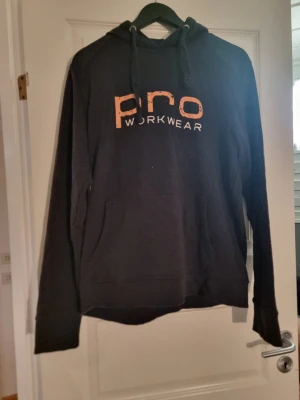 Pro workwear hoodie - Ganska bra skick utan att texten på framsidan håller på att flagna.      Har andvänt några gånger och säljer för att den är förstor 