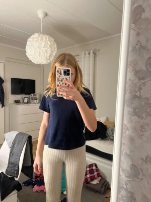 Beige ribbade bootcut byxor - Säljer ett par beige ribbade byxor med bootcut och slits vid benslut. De har hög midja och är gjorda i mjukt stickat material som är riktigt skönt. Perfekta för dig som gillar en chill och trendig look.