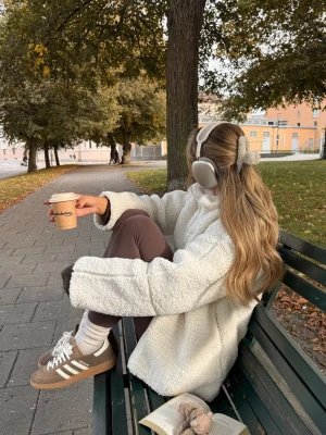 Vit teddyjacka med dragkedja - Supermjuk och fluffig vit teddyjacka med hög krage och dragkedja framtill. Jackan har en oversized passform och breda ärmar, perfekt för kyliga dagar. Materialet är fleece-liknande och ger en mysig vibe. Enkel att styla till både jeans och leggings.