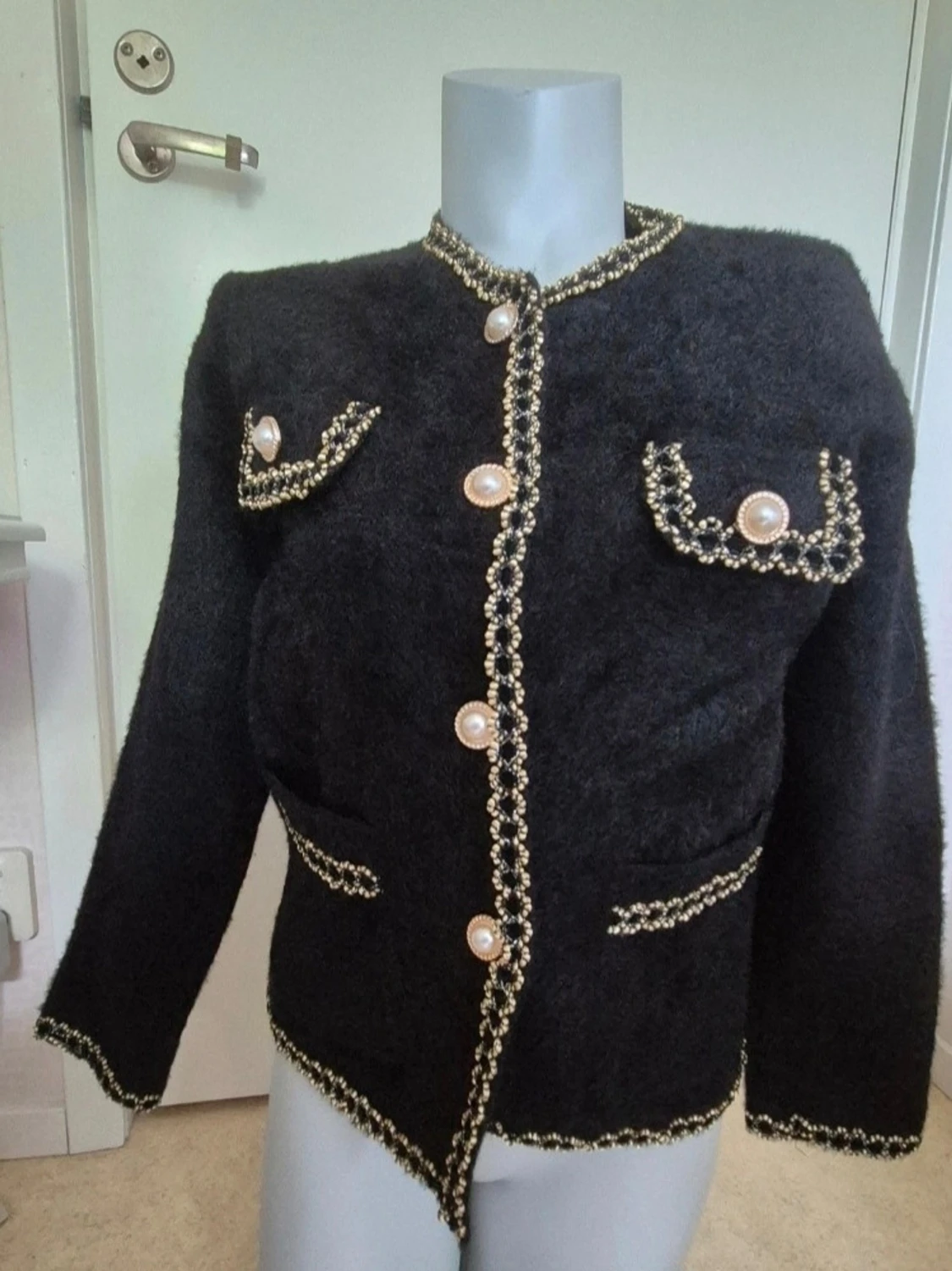 Mycket elegant svart kofta med pÀrlknappar