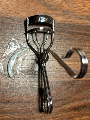 XLASH Ögonfransböjare - En fräsch ögonfransböjare från XLASH. jag skickar böjaren tillsammans med en helt ny kudde som visas i plastförpackning på bilden. 