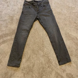 Grå slim jeans från Jack & Jones - Säljer ett par gråa slim fit jeans från Jack & Jones, modell Glenn. Har använd fåtal gånger och färgen är snyggt tvättad grå.