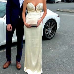 Champagnefärgad axelbandslös långklänning - Säljer nu min balklänning då den inte kommer komma till användning något mer🥰Det är inga fläckar eller andra skråmor, endast använd 1 gång! Passar mig som använder storlek S. Skriv om ni har frågor eller vill ha mer exakta mått. Klänningen är från ett Australienskt märke vid namn Lexi, en tullavgift på 1200kr tillkom där av priset. Klänningen är även helt slutsåld på deras hemsida😊