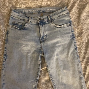 Ljusblå low flare jeans med låg midja - Snygga ljusblå jeans från bikbok med låg midja och flare-ben. Jeansen har klassisk femficksdesign, bälteshällor och knappgylf. Materialet är denim i bomullsmix med en tvättad look som ger en cool vibe. 