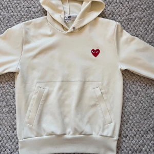 Cremefärgad hoodie Comme des Garçons🤩🙌 - Säljer en cremefärgad hoodie från Comme des Garçons PLAY med det ikoniska röda hjärtat broderat på bröstet.  Hoodien är i storlek S🙌🤩