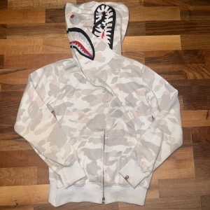 Vit camo Bape Shark hoodie storlek M - Säljer min vit camo Bape Shark hoodie i storlek M men passar bättre med dom som har S. Ni som har M det kommer sitta ganska tajt på er.