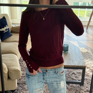 Vinröd långärmad tröja med knappar - Så fin vinröd tröja med guldiga knappar, super fint skick men en liten defekt (se bild två) inget man tänker på eller som förvärras vid användning!❤️storlek M men passar mig som har S
