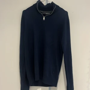 Mörkblå half zip tröja Jack & Jones - Mörkblå långärmad tröja från Jack & Jones med half zip-dragkedja i halsen. Tröjan har en stilren och enkel design, perfekt för lager-på-lager och passar till många olika outfits. Materialet är mjukt och bekvämt.