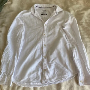 Jack & Jones essentials skjorta vit - Säljer en vit skjorta från Jack & Jones Essentials med krage och knappar där fram. Skjortan är gjort av en mix av bomull och linne. Passar perfekt för festligheter 