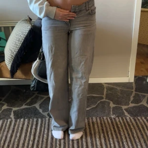 Gråa raka jeans med låg midja från ginatricot  - Säljer ett par gråa jeans med låg midja och raka ben från ginatricot. Jeansen är i storlek 32 och är andvända ett fåtal gånger.