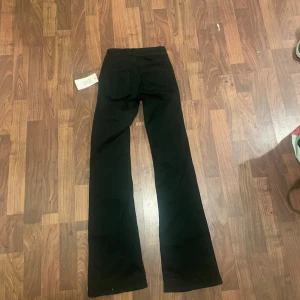 Svarta bootcut jeans från Nelly - Svarta jeans från Nelly med låg midja och bootcut-ben.                               köpte jeansen online men tyvärr tog jag fel storlek❤️. Orginal priset är 699kr som det står på prislappen och jar aödrog använts bara  testat en gång! Kom dm för fler frågor eller prisförlag! Jeansen heter ⤵️ Low Waist Perfect Bootcut Jeans I färgen Black❤️,                                    Pris kan diskuteras!!