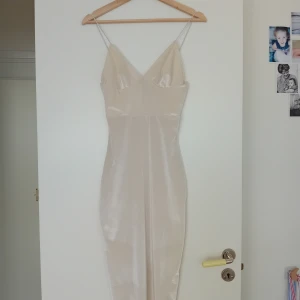 Rebecca Stella vit klänning S - Helt fantastiskt vacker klänning, och väldigt smickrande. Endast använd någon gång, men har en obehandlad sminkfläck på ena bandet (syns inte direkt på) samt uppsydd axelband (för att passa när man inte har enorma 🥥🥥). Vitt sammet material.