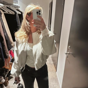 Ljusgrå croppad bomberjacka från Zara - Säljer en ljusgrå croppad bomberjacka från Zara med rund hals, ballongärmar och dragkedja framtill. Jackan har en oversized passform. Använt typ 2 gånger, inga defekter. 