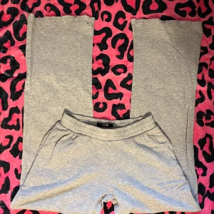 Grå mjukisbyxor från Bikbok - Grå mjukisbyxor från Bikbok i storlek S. Byxorna har elastisk midja med snörning och raka ben. Tillverkade i mjukt bomullsmaterial som är skönt mot huden. Perfekta för chill dagar hemma eller när du vill vara extra bekväm.