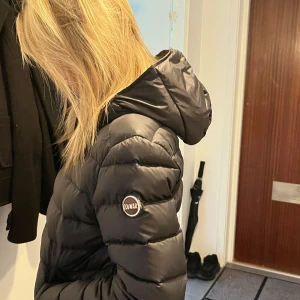Svart Colmar dunjacka med huva - Säljer en svart dunjacka från Colmar med huva och dragkedja framtill. 