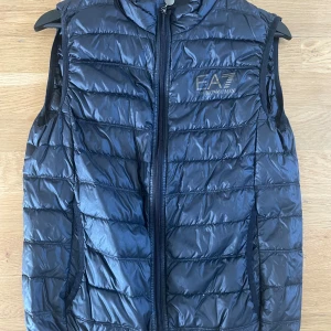 Svart dunväst från EA7 Emporio Armani - Svart EA7 väst, osäker på storleken men ungefär för dig som är 170 Cm. Mer info i PM! 