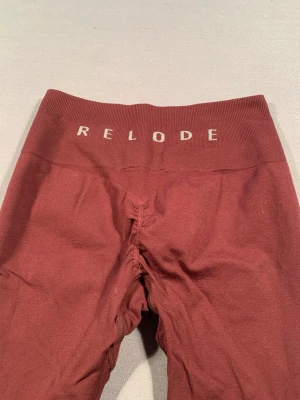 Vinröda leggings från Relode - Snygga vinröda leggings från Relode med hög midja och bred resår med logga. Tight passform och stretchigt material som passar perfekt till träning eller chill. Materialet känns mjukt och följsamt mot kroppen.