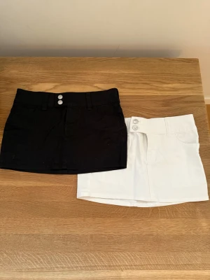 Svart och vit minikjol med fickor - Två snygga mini kjolar i svart och vitt, båda med klassisk jeanslook och fickor både fram och bak. De  är aldrig använda utan endast testade