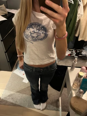 Vit t-shirt Party Queen - Säljer en vit croppad t-shirt från Jaded med blått discokula-tryck och texten 'Party Queen' på framsidan. T-shirten har korta ärmar och är gjord i mjuk bomull. Perfekt för dig som gillar coola och unika prints. Köpt för 500kr